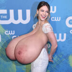 Me.Be. in a revealing white dress exposing her huge tits
