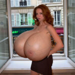 Fr.Ca. exposing her huge silicone tits by the window